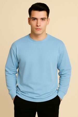 Young man wearing an oversized baby blue full sleeve T-shirt with clean seams, styled against a beige backdrop