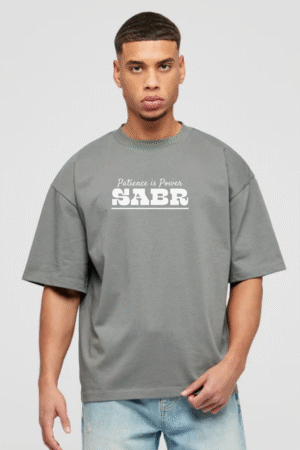 Man wearing grey oversized t-shirt with “Patience is Power – Sabr” quote printed on chest, modest faith-based streetwear from VedFra Clothing