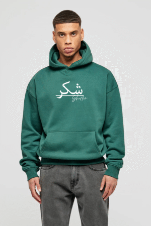 Man wearing forest green hoodie with Arabic “Shukr” design – modest streetwear by VedFra Clothing