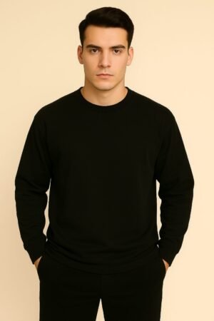 Model in an oversized black full sleeve T-shirt standing with a calm expression, neutral background.